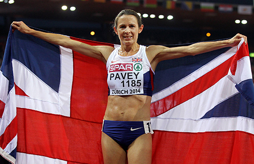 Jo Pavey celebrating with the Great Britain flag after a race .