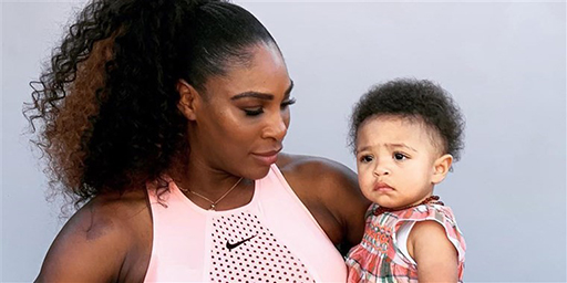 Serena Williams holding her daughter on her hip.