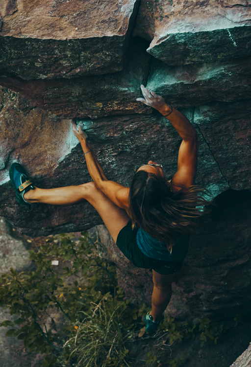 A woman climbing up a rock face.