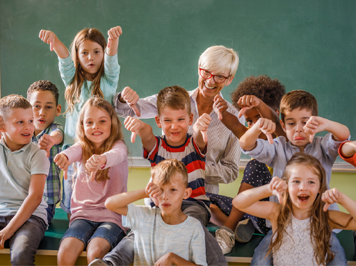This is a photograph of an adult and a group of children in a classroom.