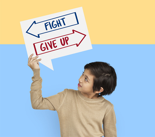 This is a photograph of a child holding a sign. On the sign are two arrows, pointing in opposite directions. One is labelled ‘Fight’ and the other is labelled ‘Give up’.