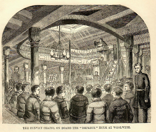This black and white illustration depicts rows of boys in uniform, seated in the timbered lower deck of a ship. Wooden stairs on the right lead up to a surrounding balcony, where a man stands in a pulpit and gesticulates as he addresses the boys.