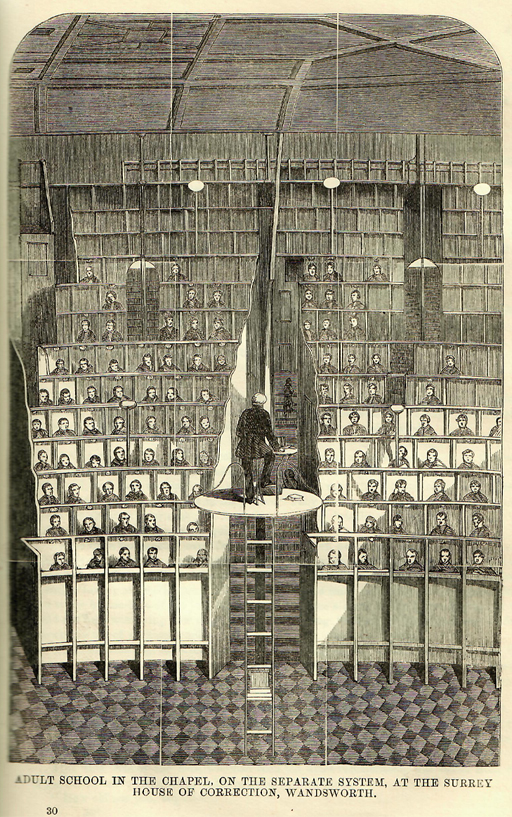 This black and white illustration depicts a lecture hall occupied by rows of men in tiered seating. Each of the men is in a separate cubicle. The schoolmaster addresses them from a raised circular platform, reached by climbing a ladder.