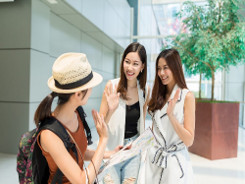 A woman waves to two female friends as she walks away.