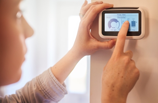 This is a photograph of a person using a smart central heating controller.