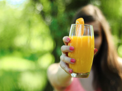 Woman holding a glass of orange juice