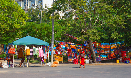 Local outdoor market in Maputo, Mozambique displaying traditional African batik paintings.