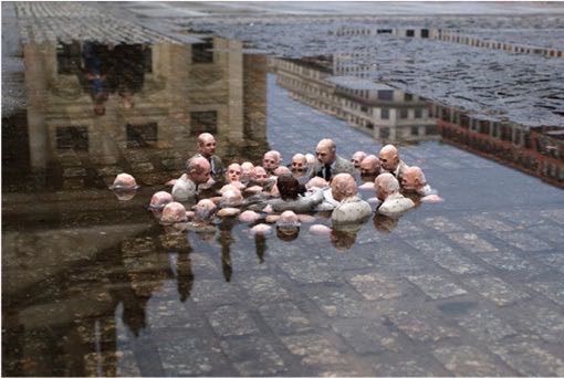This photo shows an art installation with a group of men in suits standing in a flooded cityscape.