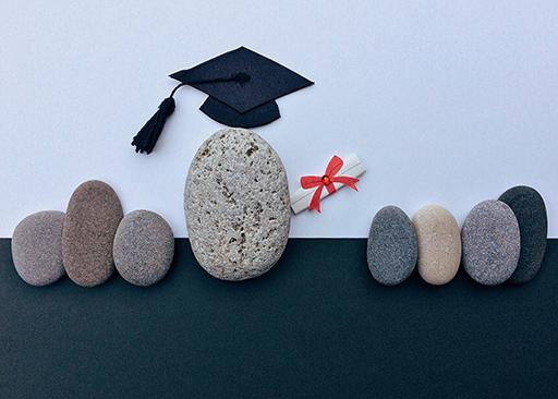 Image of pebbles representing people. One has a mortar board and a rolled up certificate.