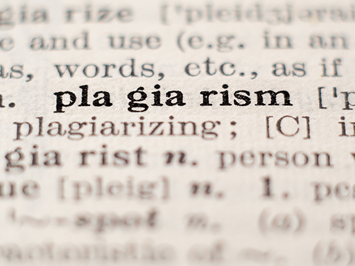 Zoomed in photo of the word ‘plagiarism’ in a dictionary.