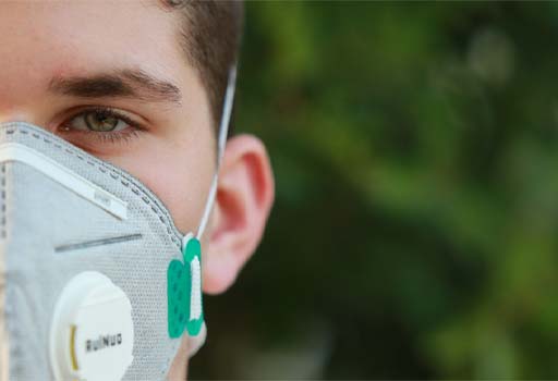 A photograph of a person wearing a medical face mask.