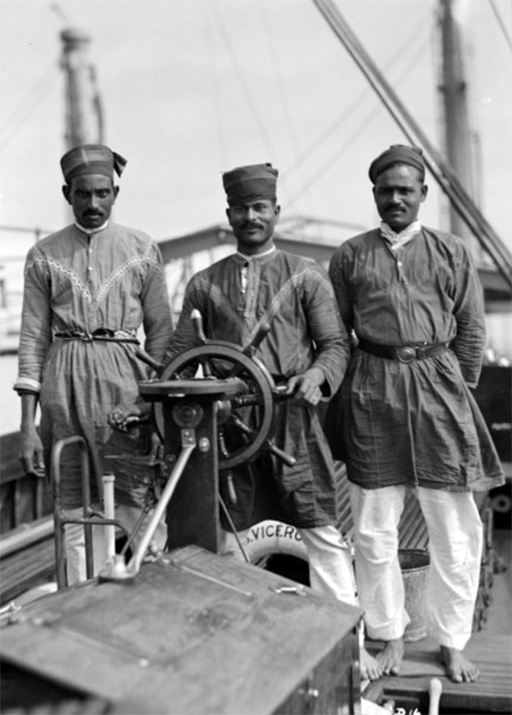 A black-and-white image of three men on a ship.