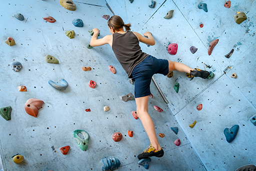 Person climbing on an indoor climbing wall.