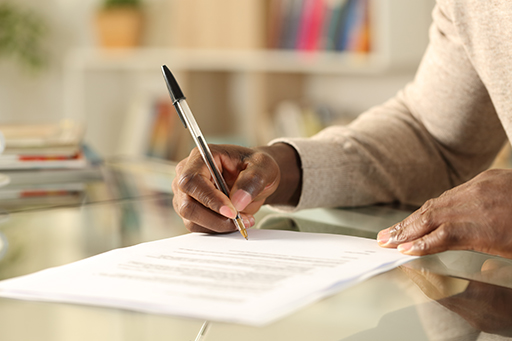 Hand of an individual signing a document