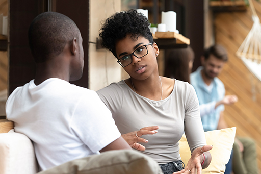 Two young individuals sat down talking.