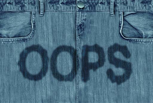 The image shows the front of a pair of denim trousers with the word ‘oops’ written on in liquid to represent urine leakage.