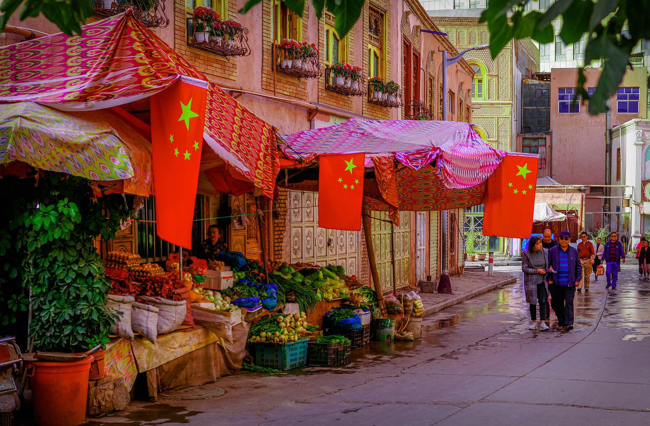 Market street in China displaying Chinese flags.
