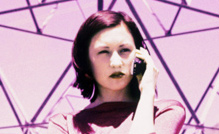 A woman on a mobile phone in front of a transmission tower