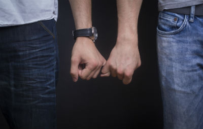 A same-sex couple link fingers