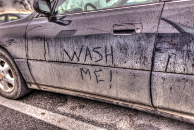 Wash me written in the dust in the side of a car