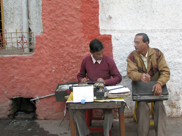 A man uses a typerwriter in an open-air office, in Kolkata, India, 2005.