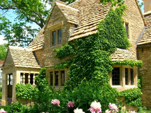 The honey coloured limestone Cotswold Cottage was built in the early 1600s in Chedworth, Gloucestershire, England.