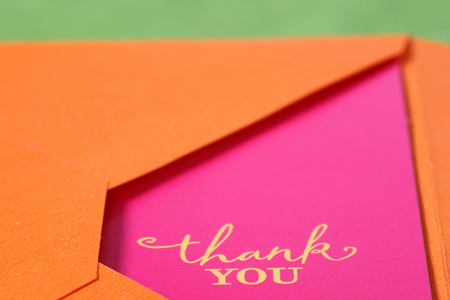 Bright pink thank you note with yellow words in an orange envelope.