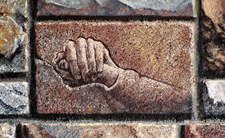 Holding hands etched into brick