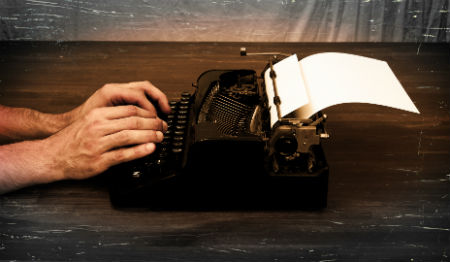 A person types on a typewriter
