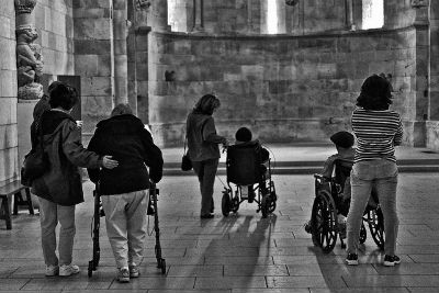 Three elderly people with Alzheimer's disease are captured on an outing at the Cloisters with their carers. 