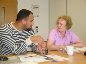 Image of a young carer and an older person talking