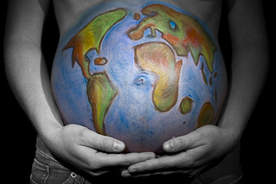 Heavily pregnant woman with world painted on her stomach
