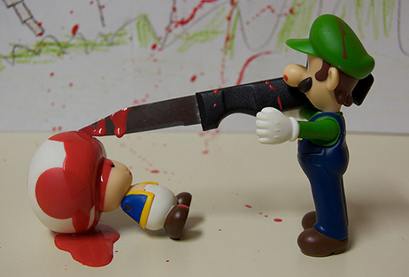 video game violence: Figurine of Luigi from the Super Mario games killing a figurine of Toad with a knife