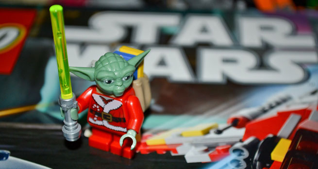 A Lego minifigure with Yoda's head on Santa's body