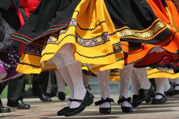 Image of spanish dancers' feet with brightly coloured skirts