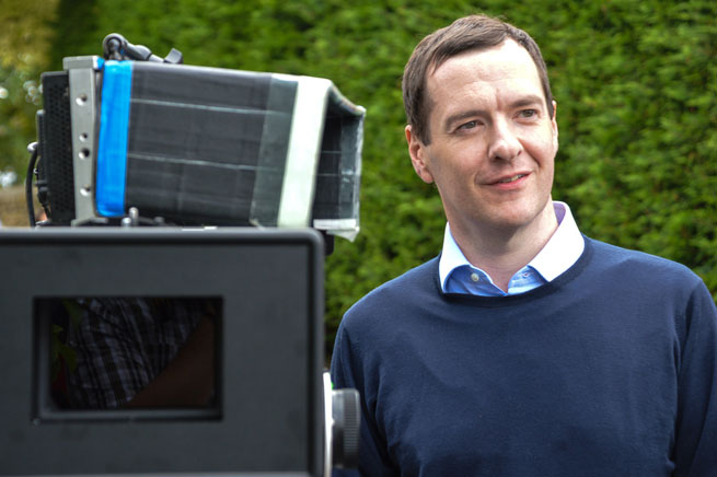George Osborne stands behind a camera