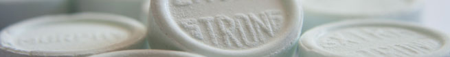 Close-up image of several white, circular pills that have 'extra strong' embossed upon them.