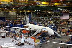 Jetstar's first 787 being built inside a big hangar, with lots of equipment and machinery. 