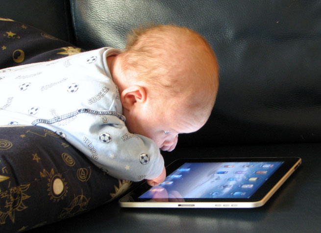 A six week old baby gazes at a first generation iPad