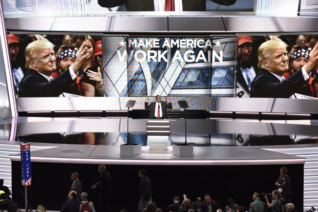 Ben Carson addresses the 2016 RNC in Cleveland, Ohio, flanked by two giant screens showing Donald Trump's face