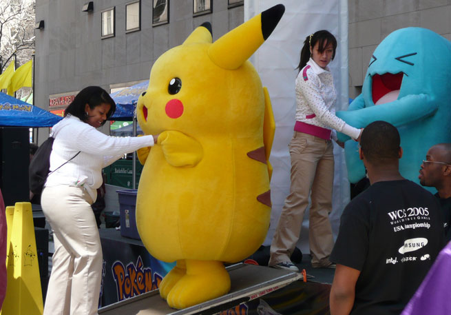 People dance with Pokemon characters including Pikachu at a New York promotional event