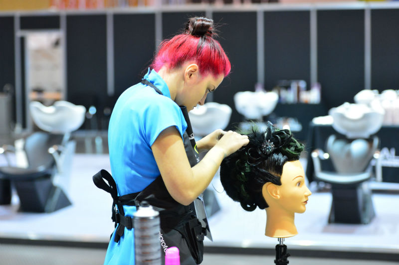 A visitor to 2012's Skills Show tries their hand at hairdressing