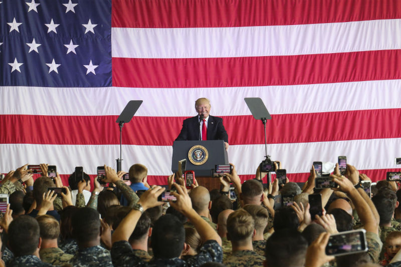 Donald Trump in front a really large American flag