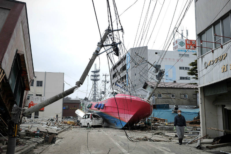 A boat lies in a street after being washed inshore by the tsunami in Hishonomaki, Miyagi prefecture on March 15, 2011
