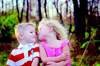 Girl and boy sitting down and being affectionate. 