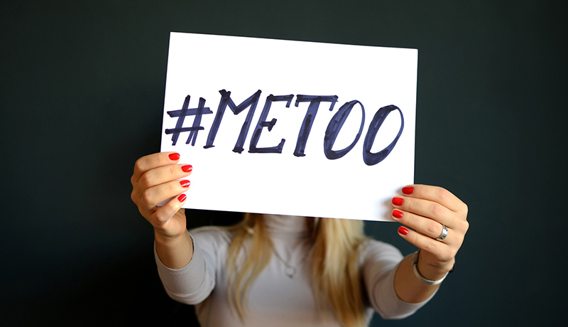 Image of girl holding up sign with text '#MeToo' 