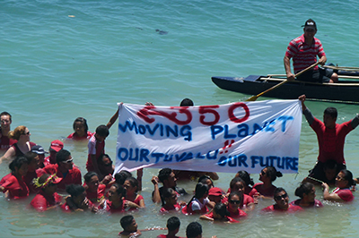 People in the sea in Tuvalu, holding up a banner