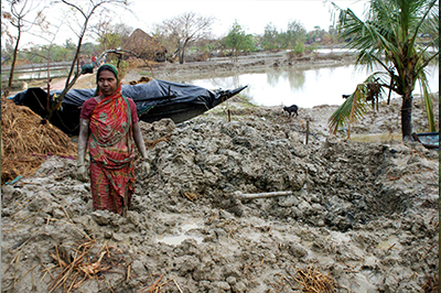 A women searching for her utensils in debris of her house which collapsed after Cyclone Aila