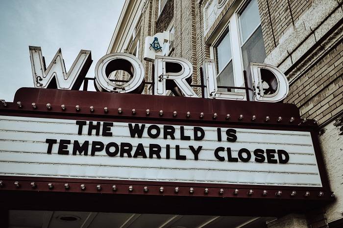A sign outside a theatre which reads 'The world is temporarily closed'