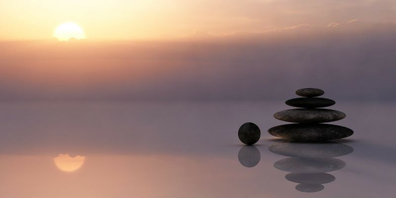 Stones piled up in front of a sunset - depicting calm